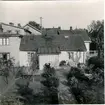 Kv. Plåtslagaren, Rödestensgatan 8. Gårdsinteriör från Rödestensgatan 6, Falköping. Tomtnumret senare ändrat till 8. Ägare var plåtslagare August Johansson, som inköpte fastigheten 1911. Mannen i stolen vid väggen är ägaren, som tydligen blivit överrumplad av fotografen.