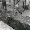 Falköpings Tidnings tomt. Fynd i jorden av en laggad trätunna. 1957. 2. Fynd i jorden av en ornerad kalksten. 1957.