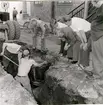 Falköpins Tidnings tomt. Fynd i jorden av en laggad trätunna. 1957. 2. Fynd i jorden av en ornerad kalksten. 1957.