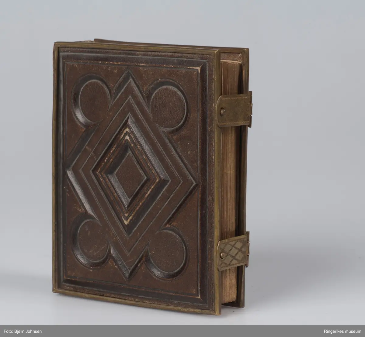 Reliffmønster på begge permer, parallellogram med fire sirkler i ytterkant.