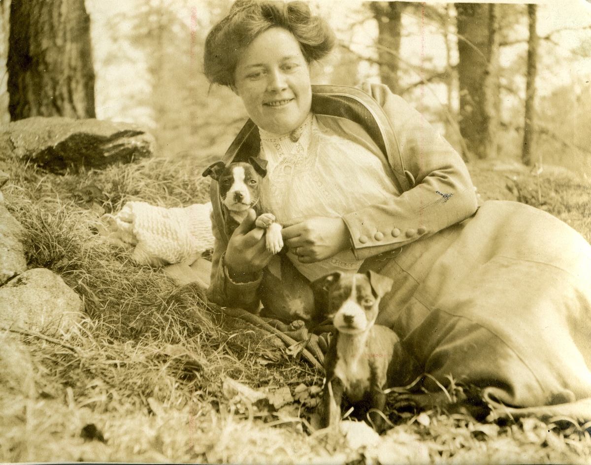 Anna Charlier-Hawtrey med hundvalpar i skogen vid St. Pauls school i Concorde, New Hampshire.