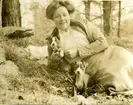 Anna Charlier-Hawtrey med hundvalpar i skogen vid St. Pauls school i Concorde, New Hampshire.