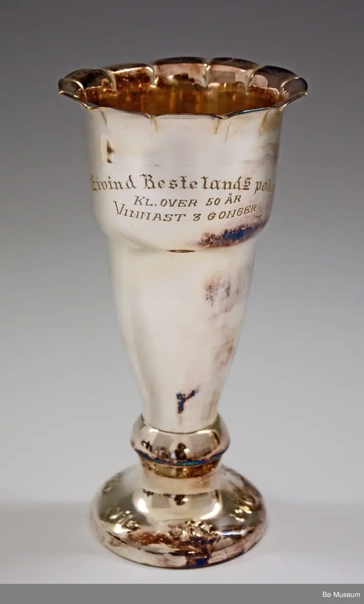 Sølvpokal med innskriften (gravering):
"Eivind Bestelands pokal - Kl. over 50 år - Vinnast 3 Gonger"
På baksida:
"Einar Bø 1955 - Andres Lia 1956 - Tor Berland 1958 - Olav O. Tveitan 1960 - Hans Kleppen 1961"
Støpt i bunnen - stempel ikke synlig.