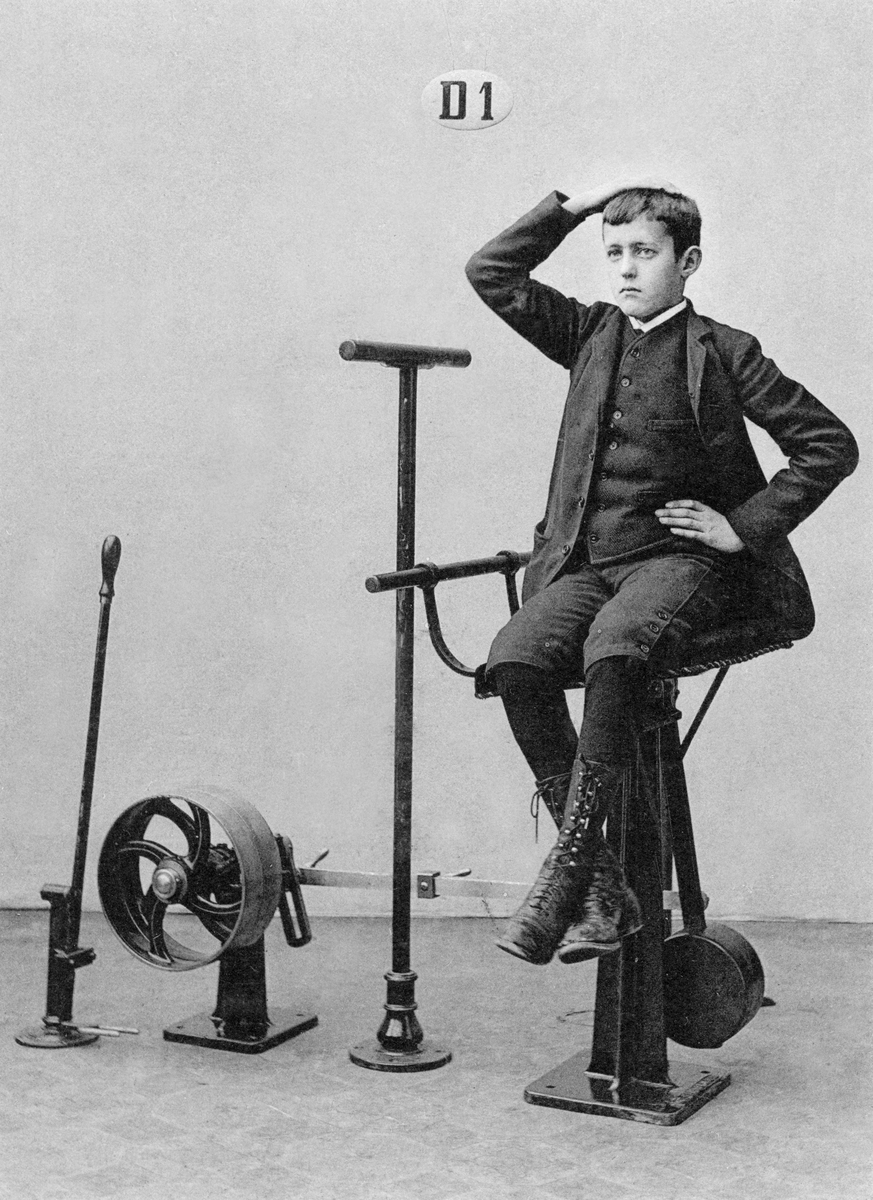 I denna barstolsliknade bålrullningsapparat stärks magmuskulaturen och tarmpaketet får sig samtligt en omgång.

English:
This boy isn’t sitting on a bar stool – it is a torso-twisting machine that is strengthening his stomach.