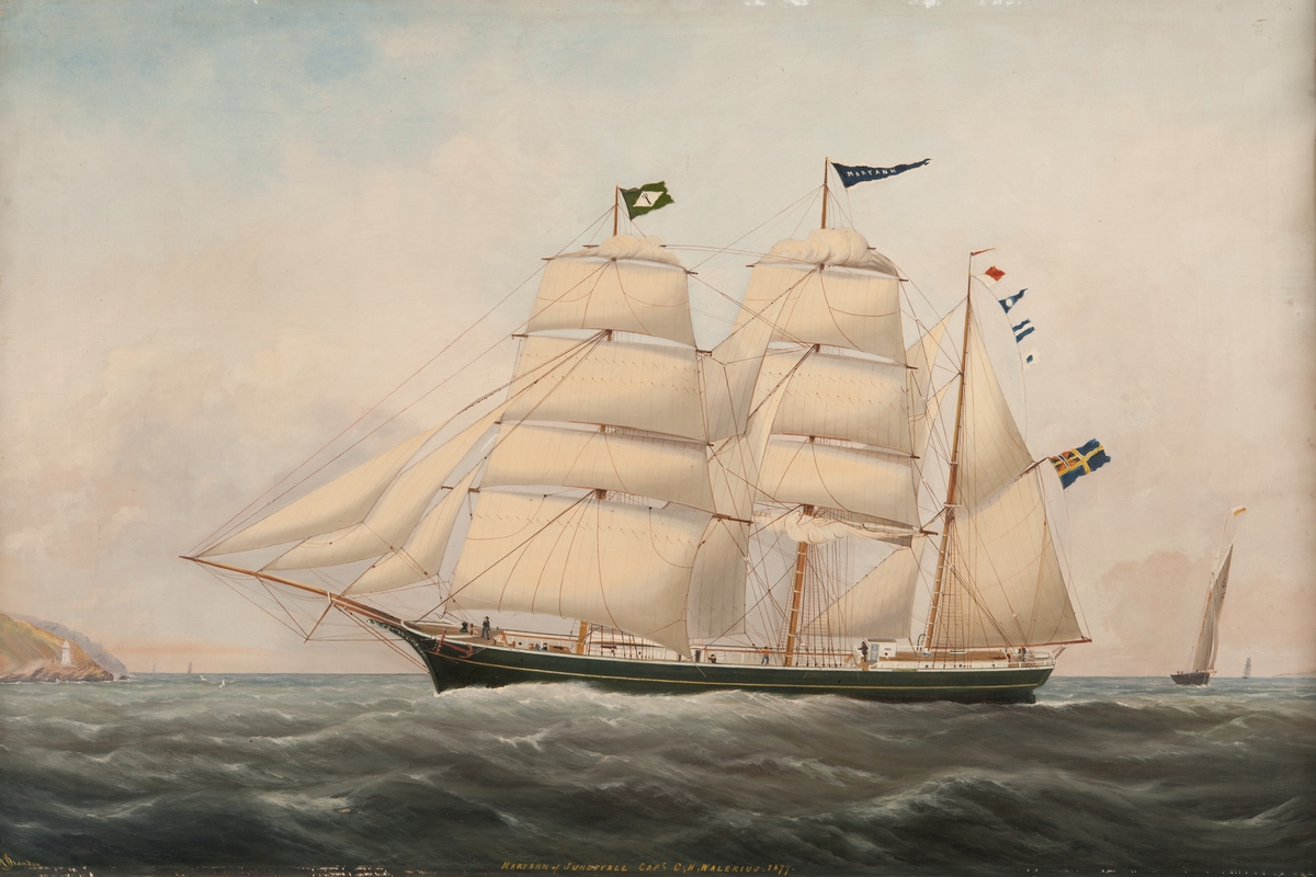 Tremastade barkskeppet MARY ANN av Sundsvall (1877), seglande för styrbords halsar, visande babords sida. Grönmålat skrov med gul list, vitmålad inombords. Unionsflagga på gaffeln. Neptuniordens flagga på fockmasten. T.v. kustparti, t.h, en jakt.
Stävornament.