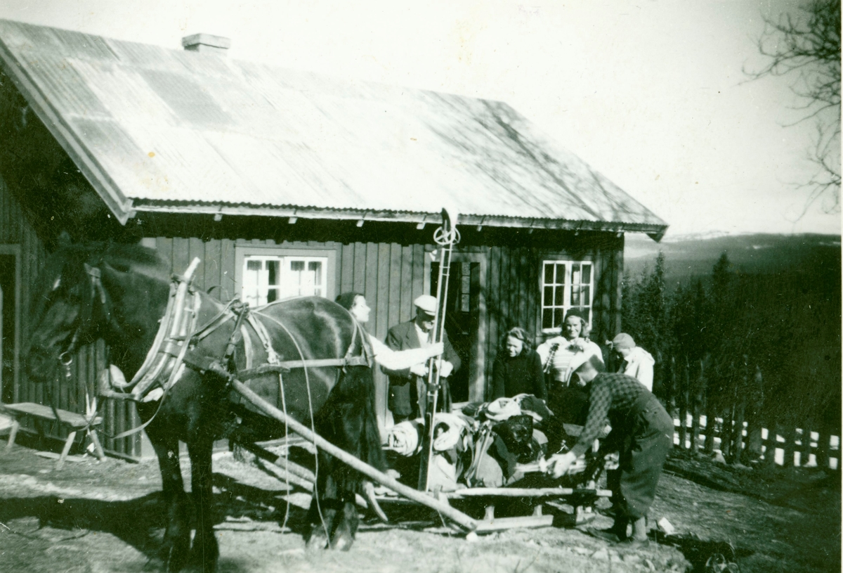 Påsketuristar skal heim frå Elbjørsvollen på Smylistølen  i 1950 åra.Andres Elbjør lastar på sleden.