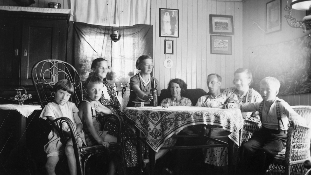 Myre, Ottestad, interiør, stue. F.v. Magnhild Dahlø, Bjørn Myhre, Berte Myhre, Tilla Myhre, OLaug Myhre, Alfred Myhre, Martha Dahlø, Alf Dahlø.