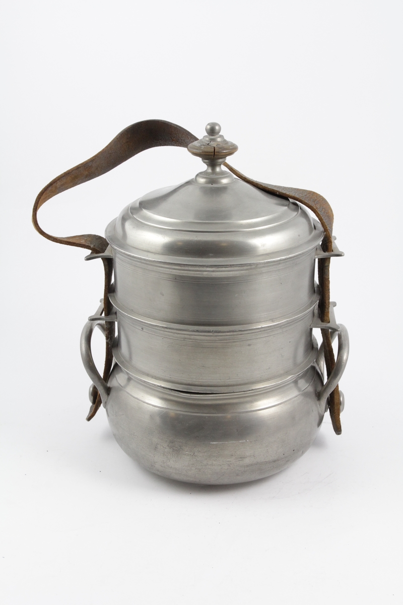 Matspann av fire deler og bærerem. 

a: Beholder. Nederste. Sirkelrund bunn med lav fotring, utbuket side, innsnevret rand. To bøyleformede hanker over snelleformet knapp. 

b: Beholder. Midtre. Sirkelrund. Svakt hvelvet bunn, med horisontal kant. vertikal side profilert ved kanten, og forsynt med to rettvinklede ører. 

c: Beholder. Som b. 

d: Lokk. Sirkelrundt, hvelvet, prydet med to konsentriske linjer, horisontal kant og dreiet knapp av tinn og tre. 

e: Rem. til å bære og forbinde delene. Lær, brun, flat med fire spaltelignende hull.