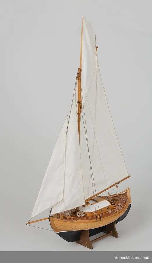 Modell av klinkbyggd kosterbåt. Gaffelriggad med bogspröt och segel, däckad och ruffad. Svartmålad botten. Detaljrik.
På styrbords kölsida, aktern, signerat med vita bokstäver:
Bengt Pettersson 2002
Påskrift midskepps:
ZAIMA
SS FRAM 1919

Ställ tillhör, ingår ej i måttangivelserna.