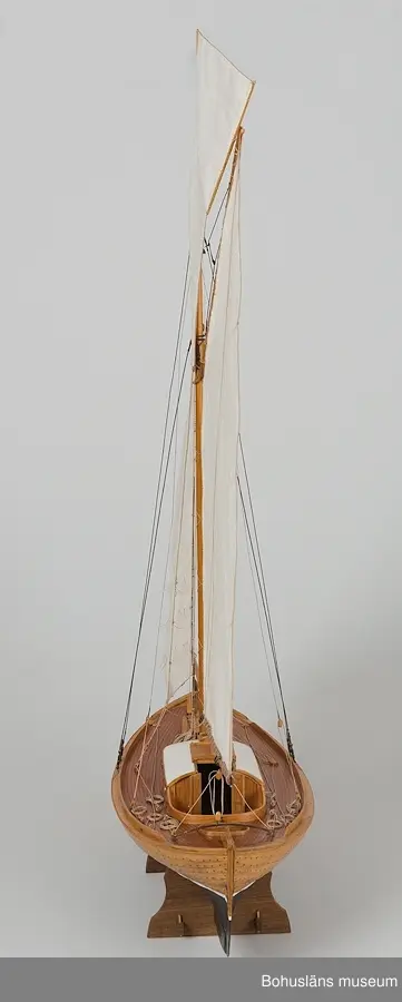 Modell av klinkbyggd kosterbåt. Gaffelriggad med bogspröt och segel, däckad och ruffad. Svartmålad botten. Detaljrik.
På styrbords kölsida, aktern, signerat med vita bokstäver:
Bengt Pettersson 2002
Påskrift midskepps:
ZAIMA
SS FRAM 1919

Ställ tillhör, ingår ej i måttangivelserna.