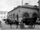 Hallsbergs Mejeri, envånings mejeribyggnad i tegel.
En täkt hästvagn för glasflaskor med texten: AB Hallsbergs Mejeri. Oskummad mjölk på glasflaskor. Telefon 153-1533.