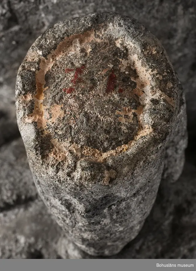 Stenskulptur av täljsten från Svarteborgs kyrka. Den helige Olof sittande i tronstol med högt ryggstöd. Han bär livbälte och mantel, en murkrona på huvudet, möjligen ett relikvarium i höger hand och håller vänster hand om skägget. Skulpturen är starkt eroderad.

Ur handskrivna katalogen 1957-1958: Olav d. helige, täljsten, Svarteborg. M: H. 41, största Br. 32,5 cm; krona och mantel, i höger hand spiran, vänster griper om skägget; sittande på en tronstol m. armstöd och högt ryggstöd, på alla håll smalnar stolen av uppåt. Starkt sliten.

Ur Katalog 1. Uddevalla Museihistoriska samlingar, svenska avdelningen. A. Yngre föremål. Upprättad av Knut Adrian Andersson 1916:                                                                                                                              No 34. Bild i täljsten av Olov den Helige. Yngre medeltiden, räknad till 1550. Förvarats i Svarteborgs kyrka under namnet "Kung Rane". Skänkt av församlingen år 1860-70-tal till Uddevalla museum. Förvaras ovanpå Medeltidsskåpet i sydvästra rummet.

Presenterad i  Uddevalla Museums tryckta katalog 1869 under rubriken 
F] Saker från yngre Medeltiden, räknad till 1550.
N:o 1. Bilder af S:t Olof i sten från Svarteborgs kyrka.

1861-1870 1 Arkeologiska och Etnografiska samlingarna U-a Museum D4A 1
Ur Gåvobok1864:
Svarteborgs församling:
Kristusbild af träd samt fragmenter af en Granit- [överstruket] Täljstensbild, enligt sägen föreställande Kung Rane, hvilka begge setat [överstruket] [oläsligt tillägg] i Svarteborgs kyrka. 
Tillagd kommentar av intendent Knut Adrian Andersson; Olof d. Helige troligen.

Se foton på föremålet i Uddevalla museums kyrkliga utställning 1920, UMFA54467:0089.
Tillstånd, se Vårdblankett.