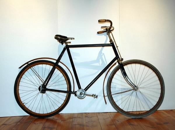 Cykel av stålrör. Diamond-ram. Spiralfjädrad, stoppad lädersadel. Styrhandtag av kork med plåtskoning. Ringklocka. Handbroms verkande på framdäcket. Fälgar och stänkskärmar av trä. Pedaler utan gummi. Kardanstång i höger bakgaffelrör. Inkapslade vinkeldrev förmedlar kraften från vevaxeln till baknavet, vilken ej har frigång. Svart med styre, gaffelkrona, gaffeländar och vevparti förnicklade. Skärmar oljade, fälgar mörkbetsade. Crescentmärke lika som föremålnummer 29816, med text "N:o 1 CRESCENT, WESTERN WHEEL WORKS, CHICAGO, U.S.A".