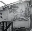 Väggmålningar i trappan till ett 1947 rivet hus vid Södra Långgatan. Grått i grått, på papper klistrat på virket. Överförda till museet.