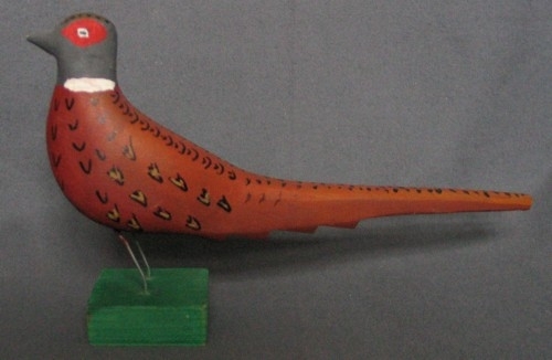 Fyra dekormålade fasaner.
a. Större fasan på 1 cm kort träben. Längd 300 mm. Stjärten avbruten.
b. Mindre fasan på ca 1 cm kort träben. Längd 200 mm.
c. Mindre fasan på högt, snett träben. 
d. Större fasan med två ståltrådsben. (Detta är troligen en kopia, både formen och färgen är annorlunda).
Fåglarna gjorda av Sven Dal, Pinkatorparn. De målades av olika kvinnor på bygden.