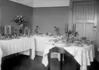 Skolköksuppvisning, tre fina dukade bord med blommor, mat och annat 1931	metallutfällning, fingeravtryck, lätta repor.