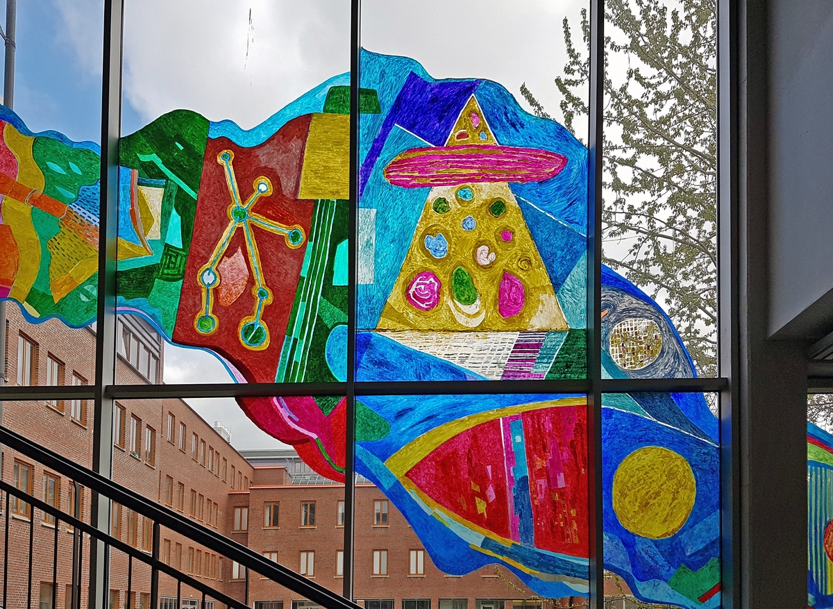 Det var den nordnorske kunstnaren Thor Erdahl (f. 1951), busett i Kabelvåg, som fekk i oppdrag å utsmykke den 50 meter lange glasfasaden i ein vestibylekorridor i bygningen. Erdahl er utdanna målar og grafikar frå Statens kunstakademi i Oslo. Han er kjend for sin ekspressive bruk av reine og skarpe fargar, som han nyttar i sterke kontrastar. I dei tidlege grafiske arbeida hans var uttrykket konkret forteljande, men etter kvart som han utvikla seg som målar, blei arbeida kjenneteikna av meir symbolske forteljingar og abstraherte, geometriske former.

Symbolbruken er også synleg i "Livets elv" i Farmasibygget. I mylderet av abstraherte naturformer kan ein innimellom sjå snev av hus, byar, båtar og andre menneskeskapte strukturar. Men ein kan også få assosiasjonar til natur og landskap, til fjell, jorde og vatn. Erdahl har tatt heile glasfasaden i bruk som lerret. Verket buktar seg bortetter veggen, akkurat slik tittelen ymtar om – som ei elv.