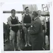 Från SM i simning, som 1946 hölls vid Långviksbadet i Kalmar.

 Nils Backlund medaljerar 2:an Rune Hellgren, Hellas. I mitten 1:an på 400 meter bröstsim John Rothman, SKK,till höger 3:an Bo Larsson, Västerås.