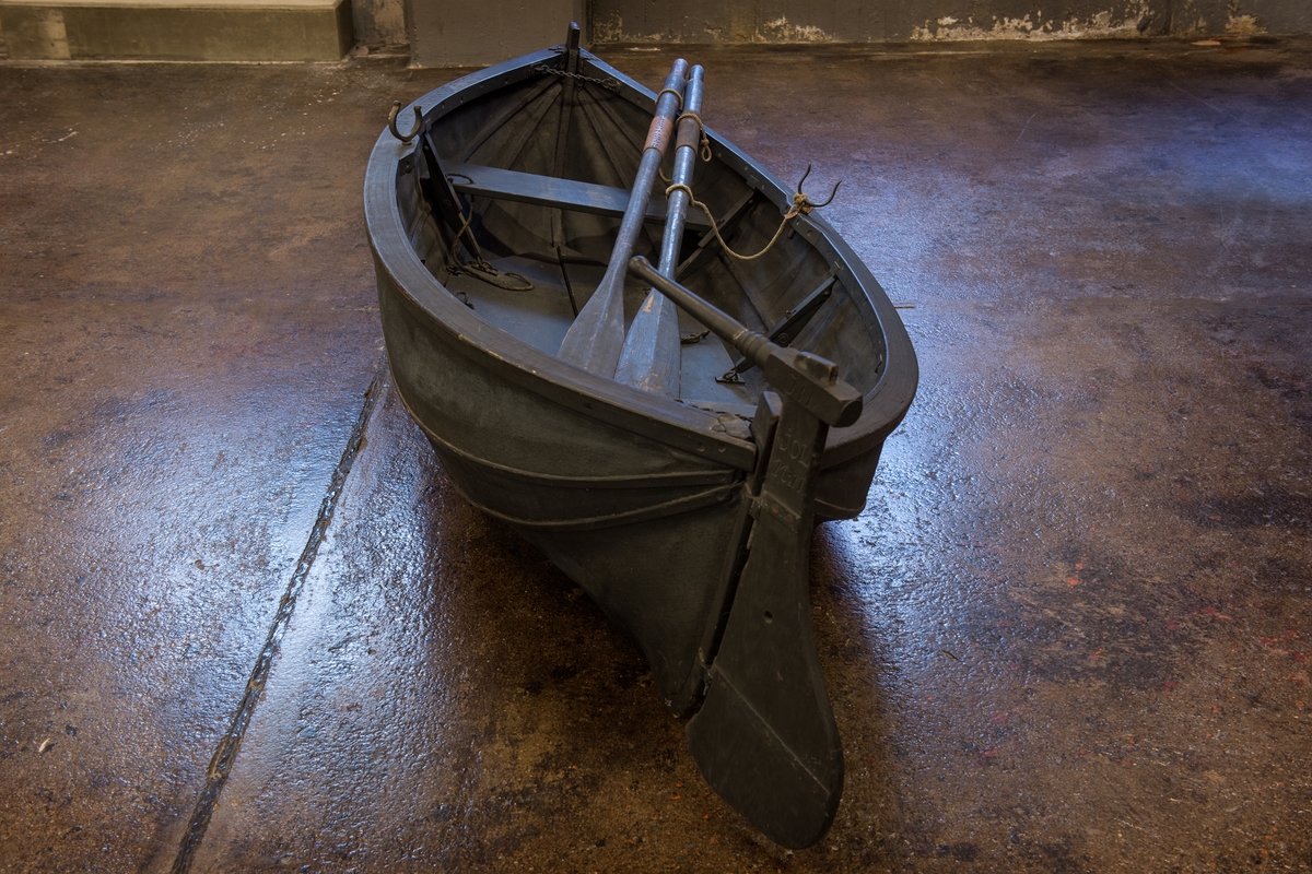 The small collapsible dinghies are sometimes called Berthon boats after their inventor and designer, the English vicar E. L. Berthon. The idea of this type of boat came to him after a maritime disaster when the steamer Orion foundered in 1849 and 150 people perished. He wanted to create a life boat that was simple to use and easy to stow aside. Ordinary life boats were bulky, and the area they occupied could be used as a promenade deck or for social activities. 

For submarines collapsible life boats were an excellent alternative, since they could easily be stored on board. Before these collapsibles were introduced, submarines used to have wooded life boats tied to ther deck, an unwieldy and impractical solutions.

The collapsible alternative to the wooden life boats are made of canvas treated with oil or paint to make it withstand water and wear. At the bottom are two board that fold against each other when the boat is not in use.

Due to the fragile nature of the canvas, the museum has chosen to keep one of the boats folded and the other unfolded.

The submarines to which they once belonged were name Hvalen (the Whale) and the Gäddan (the Pike). The Hvalen was the second submarine in the navy (the first was called Hajen, the Shark and was built at the Galärvarvet in great secrect and lanched in 1904). Submarine No. 2 Hvalen was built in La Specia in Italy in 1909. She took herself all the way from Italy to Sweden, by then the longest journey ever undertaken by a submarine. The Hvalen was decommissioned as early as 1919. 

The Gäddan was built at the Örlogsvarvet (the naval dockyard) in Karlskorna in 1915. For her day she was very advanced and could reach a depth of 35m. The Gäddan was taken out of service in 1935. 

Both dinghies were donated to the National Maritime Museum by the Stockholm naval dockyard in 1966.  