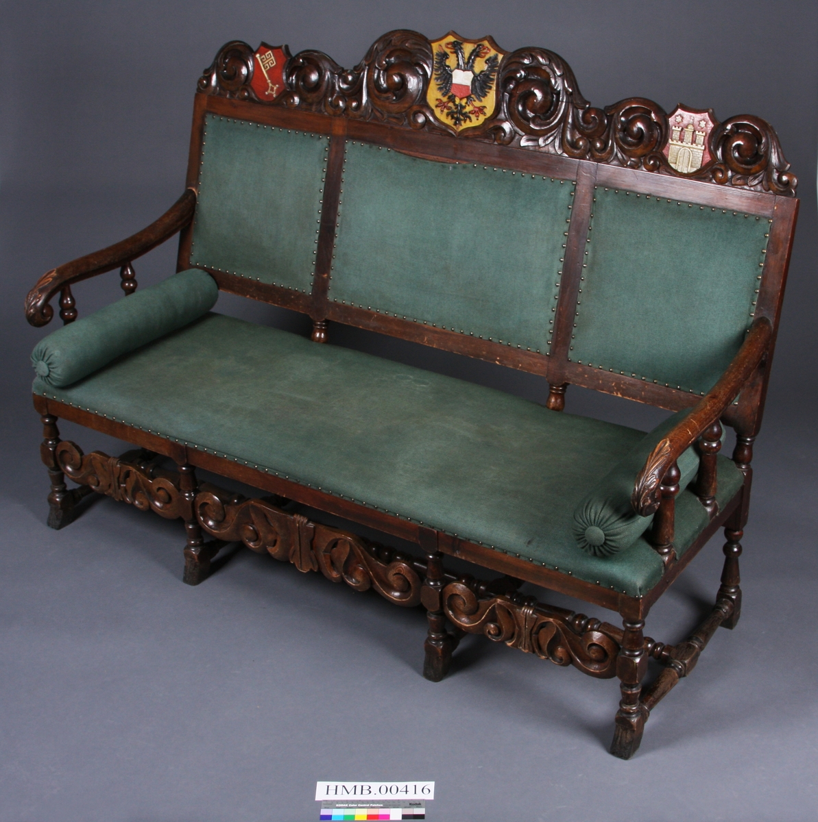 I utskjæringene over tre felter i sofaens rygg er det våpenskjold (byvåpen). Det venstre har en nøkkel, det i midten er Lübecks dobbeltørn, det høyre har en borg med tre tårn og en port. Over to av tårnene er det en stjerne, over tårnet i midten et kors. Rundt våpenskjoldene (byvåpnene) er det ranker og blad. I midtstykket mellom sofaens frontbein er det også ranker, og på armlene er det blad.