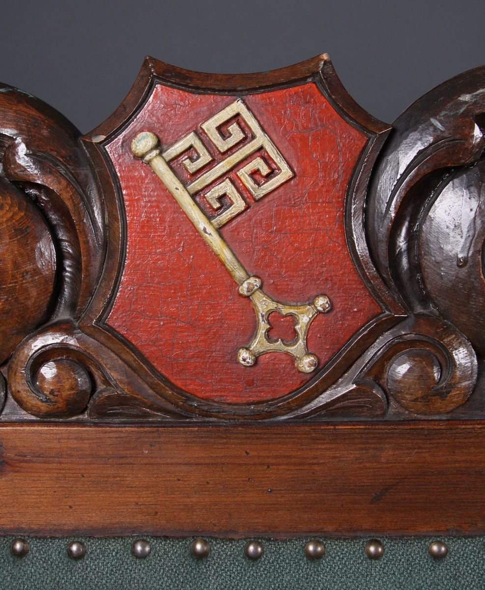 I utskjæringene over tre felter i sofaens rygg er det våpenskjold (byvåpen). Det venstre har en nøkkel, det i midten er Lübecks dobbeltørn, det høyre har en borg med tre tårn og en port. Over to av tårnene er det en stjerne, over tårnet i midten et kors. Rundt våpenskjoldene (byvåpnene) er det ranker og blad. I midtstykket mellom sofaens frontbein er det også ranker, og på armlene er det blad.