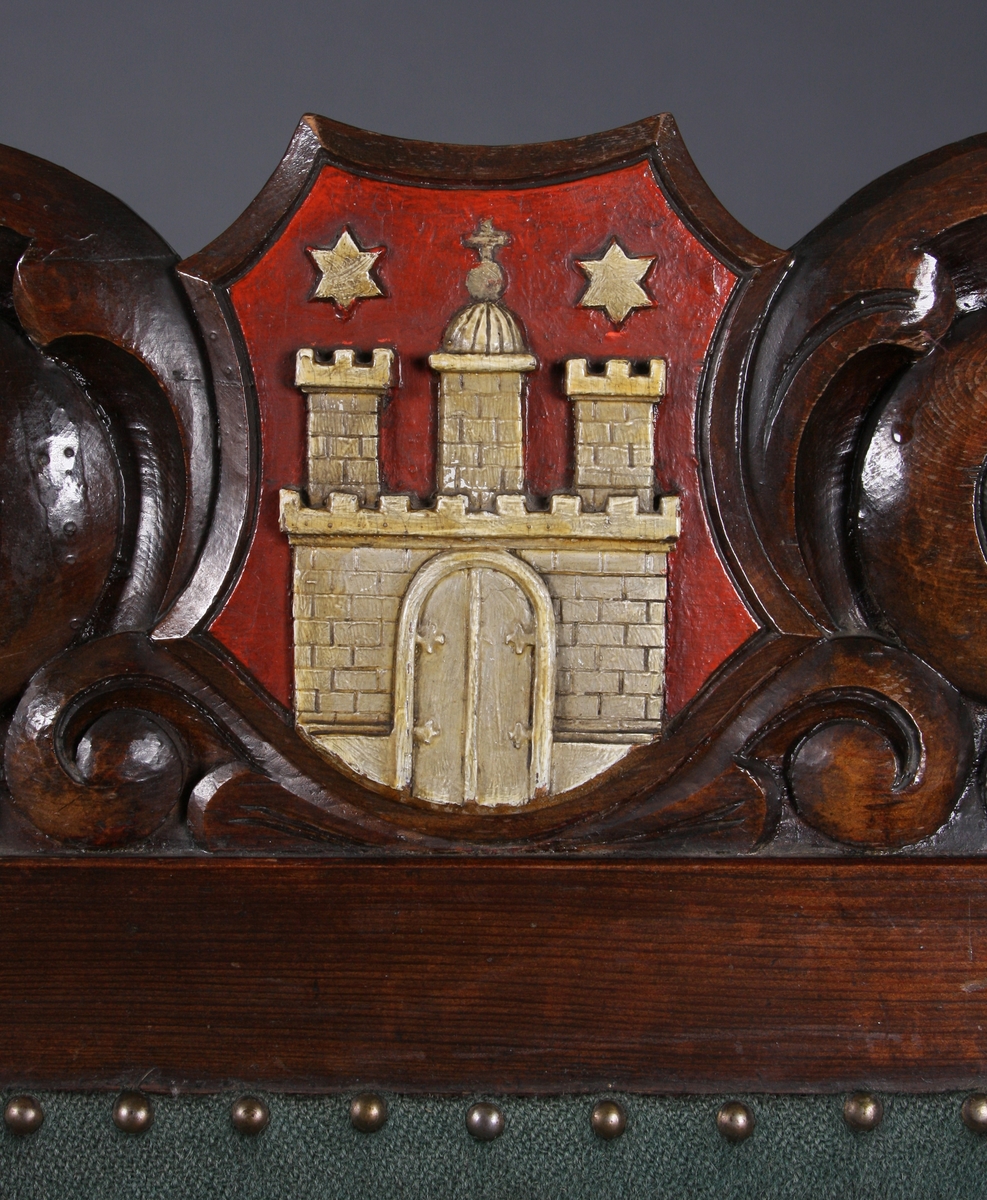 I utskjæringene over tre felter i sofaens rygg er det våpenskjold (byvåpen). Det venstre har en nøkkel, det i midten er Lübecks dobbeltørn, det høyre har en borg med tre tårn og en port. Over to av tårnene er det en stjerne, over tårnet i midten et kors. Rundt våpenskjoldene (byvåpnene) er det ranker og blad. I midtstykket mellom sofaens frontbein er det også ranker, og på armlene er det blad.