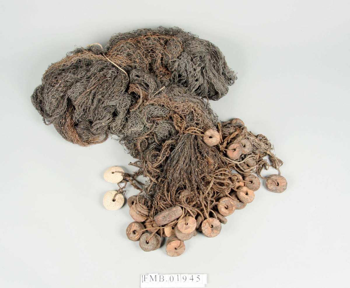 Sildegarn med fløyt av furubark og synkene av stein (delvis asbestholdig) med hull i midten. Synk og fløyt er runde. Telnene er treslått snøre.