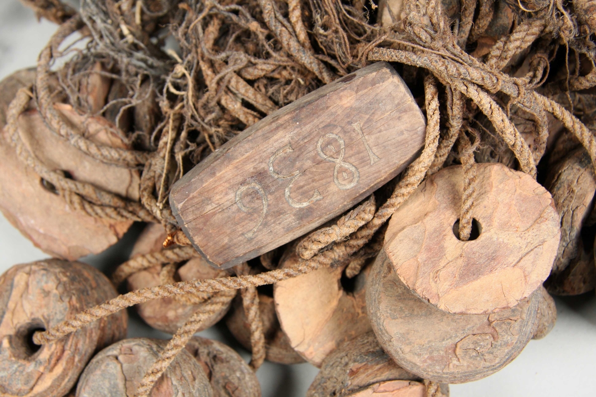 Sildegarn med fløyt av furubark og synkene av stein (delvis asbestholdig) med hull i midten. Synk og fløyt er runde. Telnene er treslått snøre.