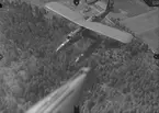 Spaningsflygplan S 12 märkt 24 från F 2 Hägernäs i luften över skog. Fotograferat ovanifrån.