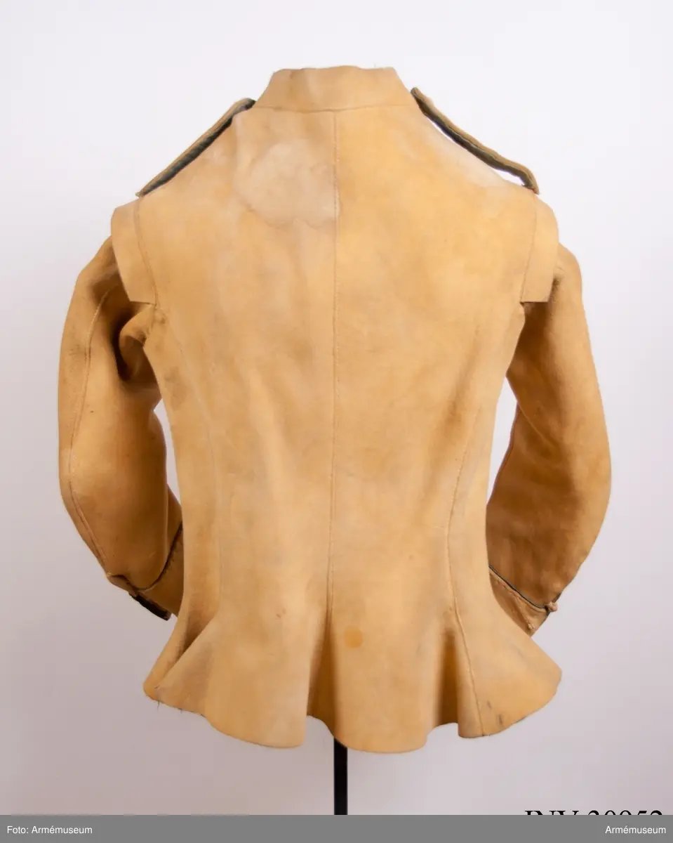 Kyller av gul älghud med blå linneband som kantning på insidan. Lätt utsvängt nertill med litet skört bak. Uppvik framtill, axelkarmar och låg krage.  Kragens linneband är i dag i upplösning och bara några trådar finns kvar.
Helt framtycke, och delat bakstycke samt två separata sidstycken. Sidsöm under ärmen.
Formade tvåsömsärmar med ärmuppslag. Ärmuppslagen har blå passpoal och sprund som knäpps med 3 koniska knappar klädda med sämskskinn i samma färg. Ett fjärde knapphål som är igensytt talar om att plagget blivit omsytt vid något tillfälle. En rad hål efter stygn på insidan av höger framstycke visar att plagget har haft en knappstolpe/underlott.
Axelklaffar fodrade med blått linne som knäpps vid kragen med samma knappar som ovan.
Plagget knäpps kant i kant mitt fram med 12 stycken hyskor och hakar av metall. Alla sömmar är sydda med oblekt lintråd.
Märkt inuti ryggen med "N 2".