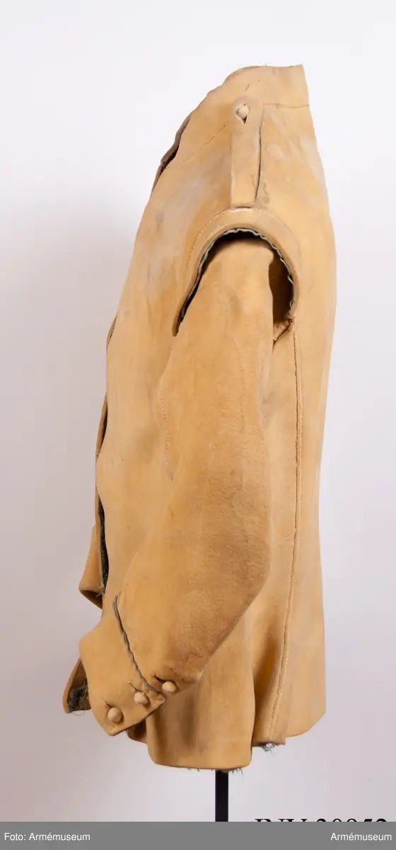 Kyller av gul älghud med blå linneband som kantning på insidan. Lätt utsvängt nertill med litet skört bak. Uppvik framtill, axelkarmar och låg krage.  Kragens linneband är i dag i upplösning och bara några trådar finns kvar.
Helt framtycke, och delat bakstycke samt två separata sidstycken. Sidsöm under ärmen.
Formade tvåsömsärmar med ärmuppslag. Ärmuppslagen har blå passpoal och sprund som knäpps med 3 koniska knappar klädda med sämskskinn i samma färg. Ett fjärde knapphål som är igensytt talar om att plagget blivit omsytt vid något tillfälle. En rad hål efter stygn på insidan av höger framstycke visar att plagget har haft en knappstolpe/underlott.
Axelklaffar fodrade med blått linne som knäpps vid kragen med samma knappar som ovan.
Plagget knäpps kant i kant mitt fram med 12 stycken hyskor och hakar av metall. Alla sömmar är sydda med oblekt lintråd.
Märkt inuti ryggen med "N 2".