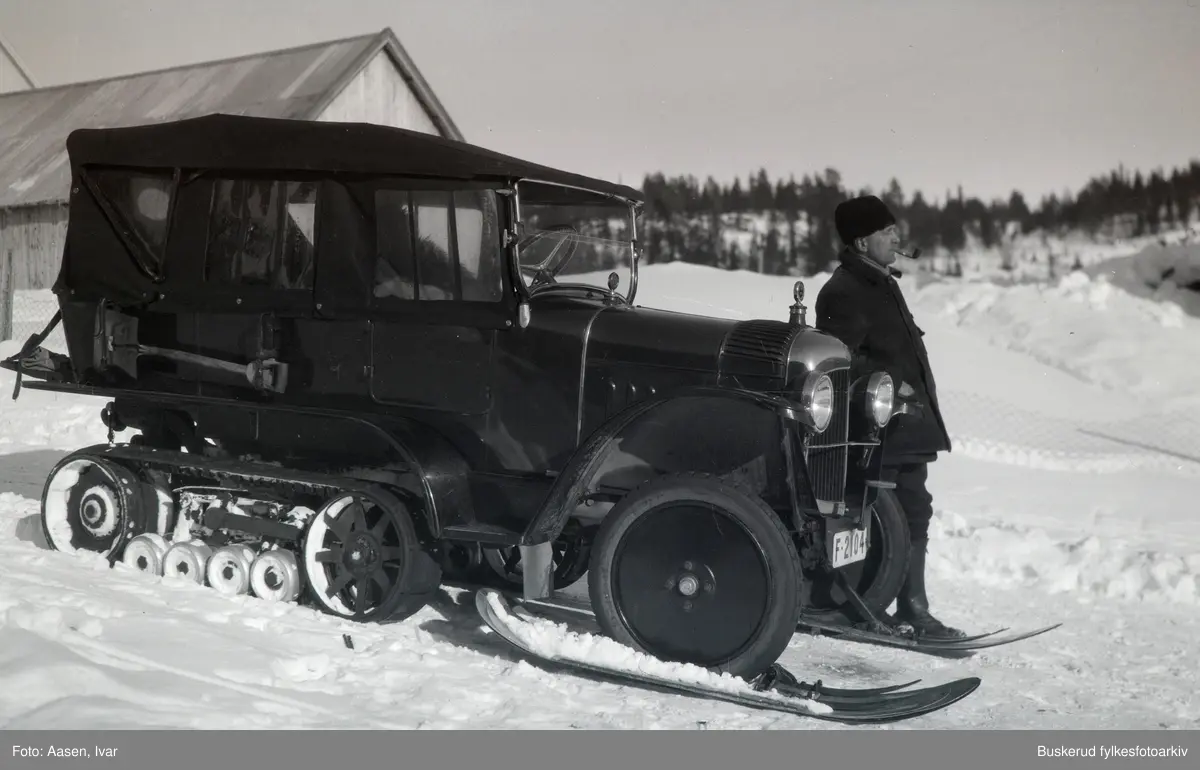 En mann står ved siden av en bil med beltedrift og meier med kjennetegn F 2104. Bilen er av typen Citroën og har beltedrift av typen Kégresse, som først var tilgjengelig i 1921.