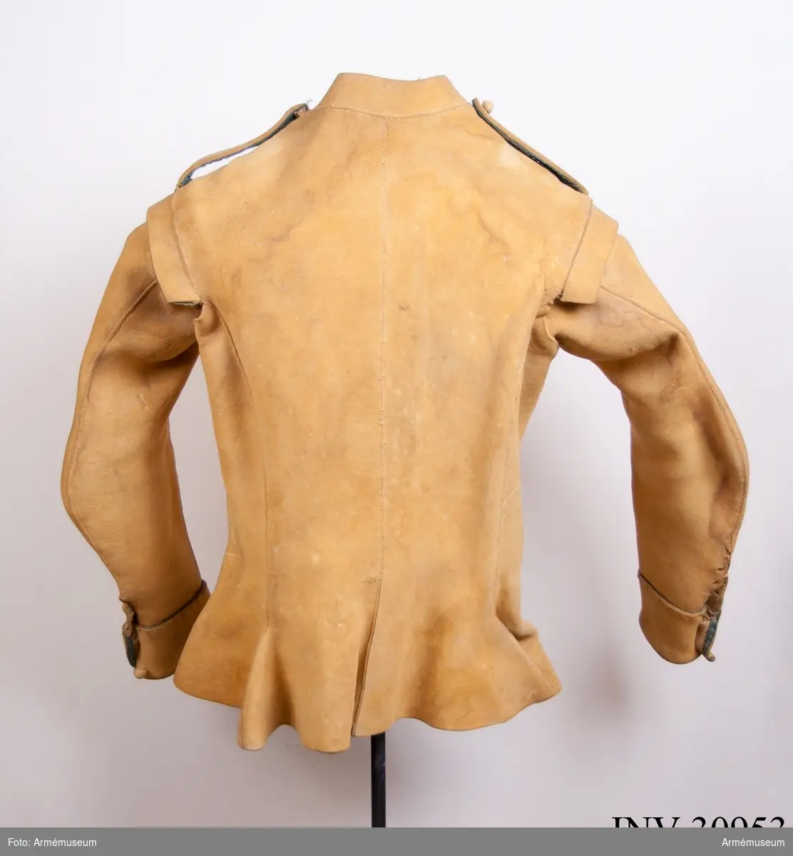 Kyller av gul älghud med smala blå linneband som kantning på insidan samt som passpoal vid övre kant av ärmuppslagen.
Helt framstycke med utsvängt kort skört med uppvik framtill, samt bakstycke med mitt-bak-söm och två sidstycken. Sidsöm under ärmen. Formad tvåsömsärm med ärmuppslag. Ärmuppslagen har sprund som knäpps med 3 koniska älghudsknappar i varje sida, även om det är utskuret 6 knapphål i höger ärm och 5 i den vänstra. De knapphål som inte används är ihopsydda. Liten axelkarm, samt axelklaffar på båda sidor som är fastsydda vid axelsömmen samt knäpps med älghudsknapp vid halsen. Knapp saknas på vänster axel.
Låg ståndkrage som har varit kantad på insidan med blått band. Detta saknas i dag.
Plagget knäpps kant i kant med 12 stycken hyskor och hakar mitt fram. Alla sömmar är sydda med oblekt lintråd.
Märkt inuti ryggen "No 1".
Kyllret skiljer sig något från samtida kyller av samma modell genom att de blå banden är smalare.