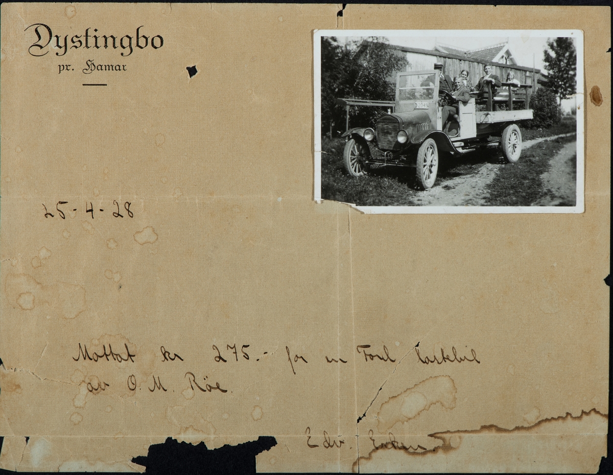 Gruppe 5 personer sittende i en Ford lastebil med reg.nr. D-2049. Kjøpt av O.M. Røe 25/4-1928 for 275 kr.