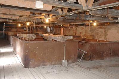 Interiør fra Klevfos, bærer preg av tidens tann. Store, rustne, tanker hvor det har vært lut