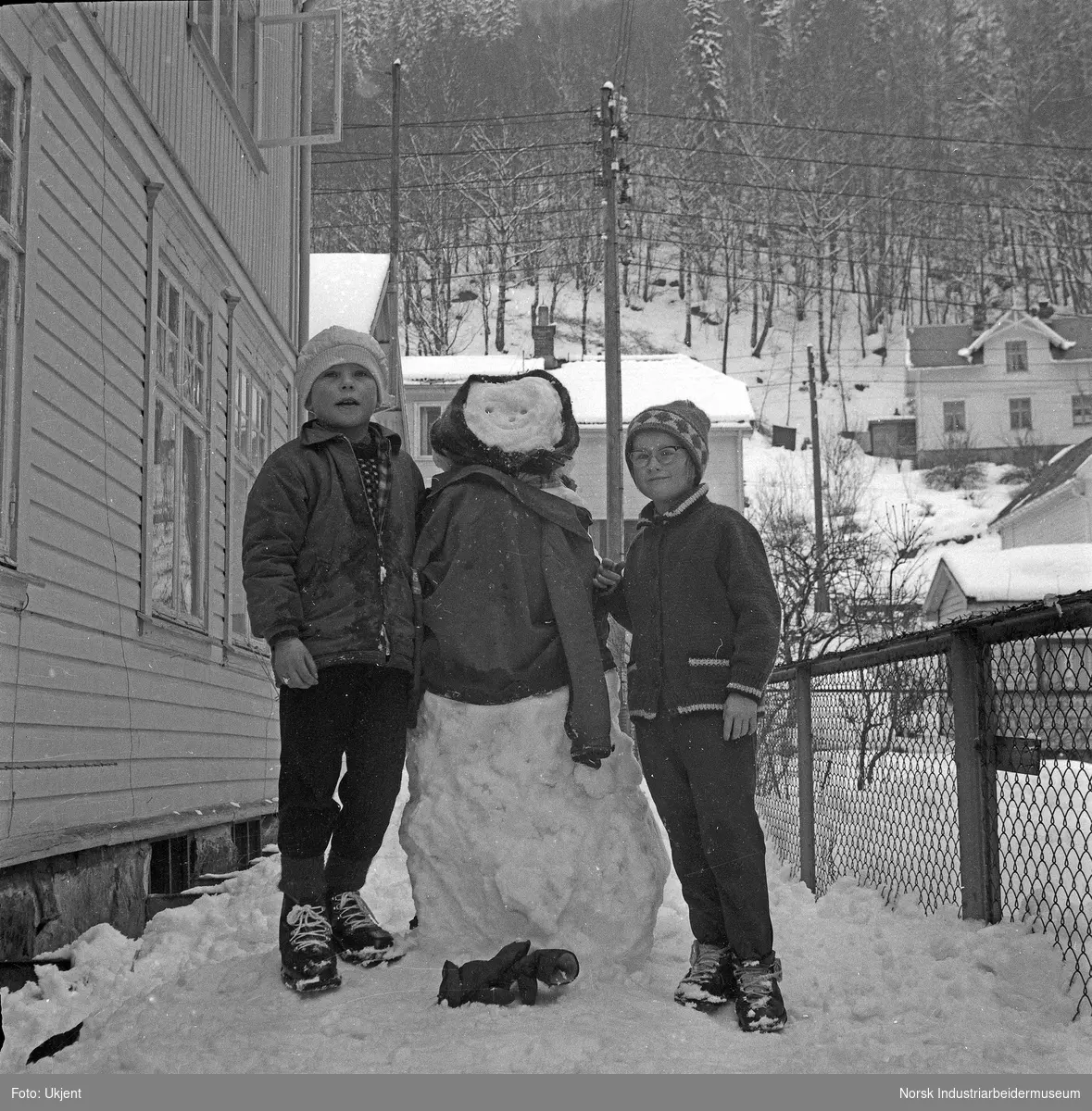 To barn med snømann i Storgata.