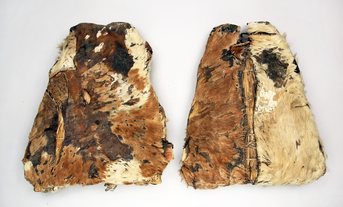 Et par truger med treramme av flatetrestykker føyd sammen i en trekant og trukket med skinn (kalveskinn) og foret med halm (rughalm). Fotbøylene er av teger.