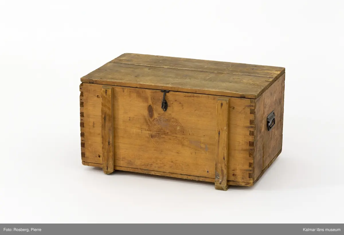 KLM 45273:74. Låda, av trä. Trälåda med lock. På gavlarna handtag av metall och på framsidan en bygel av metall där man kan stänga låda med ett hänglås.  På fram- och baksidan stämplad med ett emblem och texten Walter S Siegel Wiesbaden. På insidan är locket stämplat i svart med texten W.S.S. 5430 och två dekorerade remmare. På lockets insida sitter också två pappersetiketter klistrade. Den ena av vitt papper har text på tyska som berättar att lådan skickats från Wiesbaden till Stockholm. Den andra etiketten av rött papper har texten Transit-gods Trälleborg.