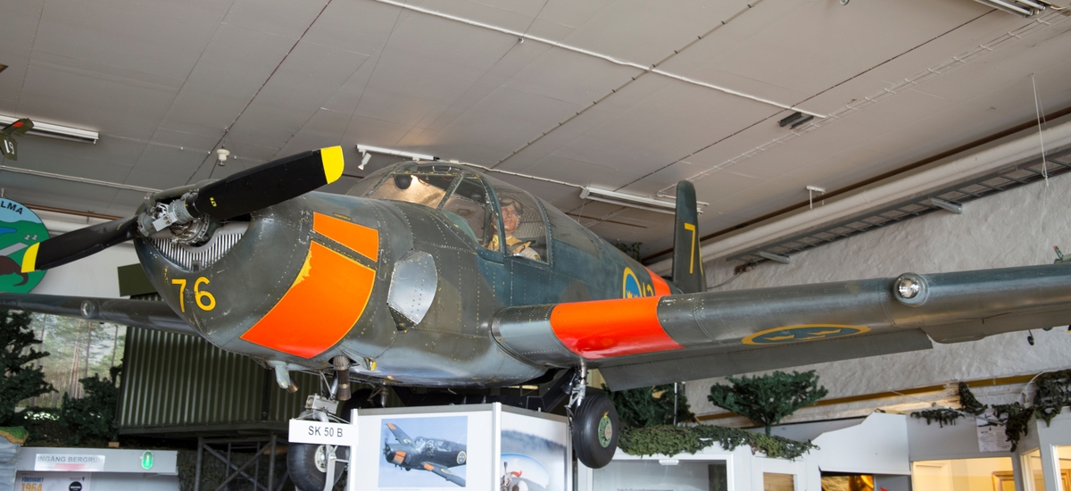Skolflygplan, SK 50B
Saab 91B Safir

Märkning: I nosspetsen kodsiffra 76; på bakkroppen kronmärke och flottiljnummer 13; på fenan kodsiffra 76. Stora orangefärgade fält på fram- och bakkropp, vingar och stabilisator visar att det är ett skolflygplan.