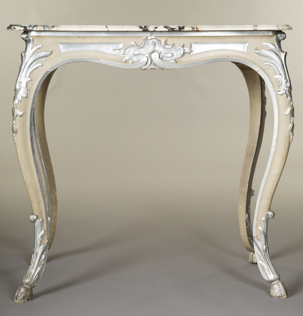 Rektangulært bord med treunderstell og marmorplate i nyrokokko. Malt lysegrått med forsølvete ornamenter. Sort og hvit marmorplate med svunget kontur. Cabrioleben med kloveavslutning. Sargens midtfelter har på kortsidene utskåret rocaille, og på langsidene skåret rankeverk. Bena har også skåret rankeverk.