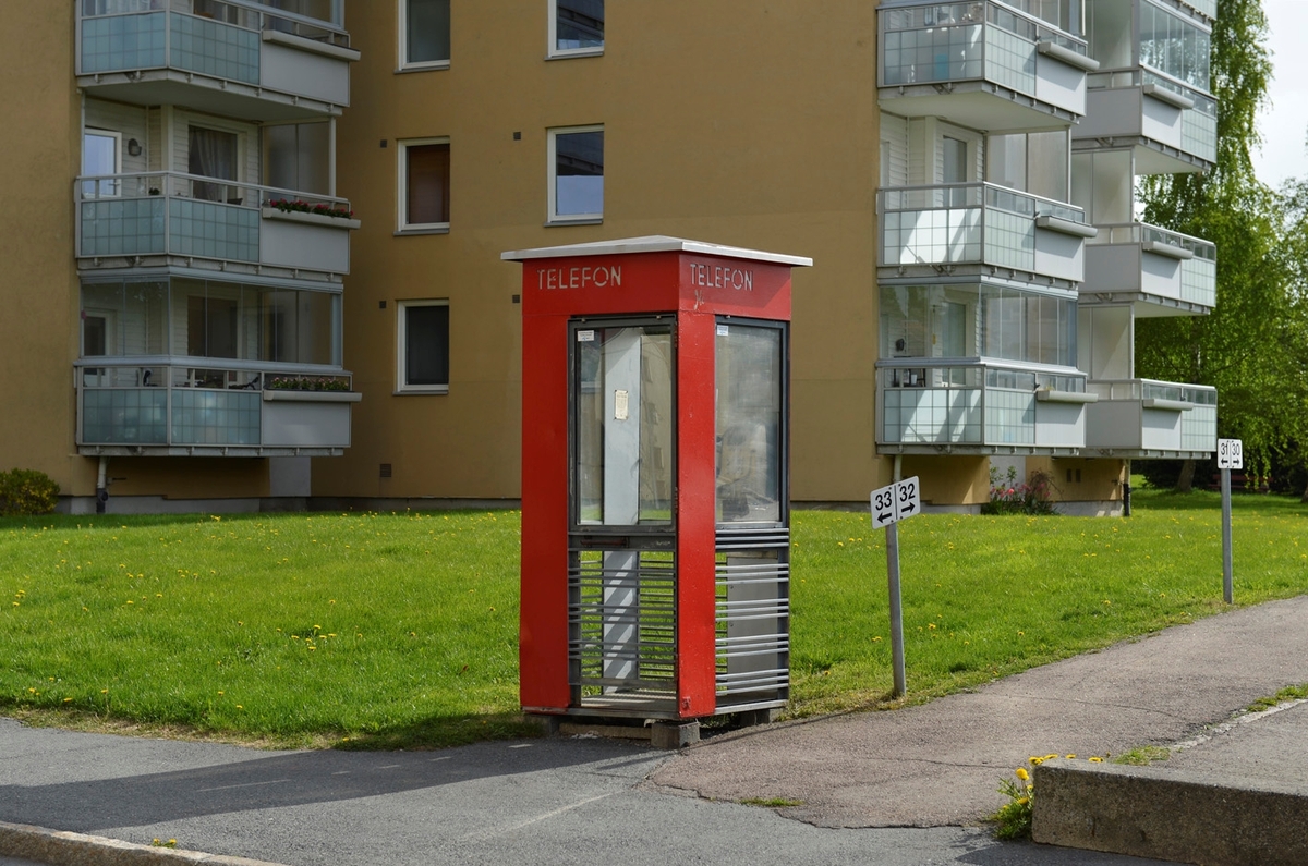 This is the story of how Norway’s most important conversation-space was designed by a young, freshly graduated man from Bergen.

“Norwegian architects are hereby invited…”
In the autumn of 1932, Oslo Telefonanlegginitiated an architectural competition. Finally, Oslo would get its own telephone booth. The city had had so called “talking-stations” from 1885, which in turn were overtaken by automatic telephones 
 only available at selected Narvesen kiosks. The state 
was of the opinion that now was the time to offer the public a better service; public telephone booths open 24/7, like the ones they already had in Sweden and England. But what would they look like, these new telephone booths? What considerations would it
 be necessary to take when designing it? The telegraph board developed a detailed list of demands and restraints: “The booth is intended to be placed outside on the streets and squares and need to be designed so that snow and ice does not hinder the opening and closing of the doors,” they wrote. “To prevent vandalism, theft, uncleanliness etc. inside the booth, it needs to be designed so that from all angles one may see what is going on in there.” Additionally, it would need to withstand storms and bad weather, and “preferably also being whipped by rain mixed with seawater” 

This was not all: The appearance would have to be «pleasing». The booth also needed to be movable, so that it could be taken in to be serviced at Telegrafverket’s main workshops. The reqired material was iron, and the surface was to be spray painted  preferably using car-body paint. There was a requirement for “a writing shelf, a pack shelf, and a suitable place for the telephone catalogue.” Also, there would need to be an illuminated TELEFON  sign, easily visible from all four angles. The total cost for each booth should not exceed 1000 kroner. The first prize for coming up with such a product was 800 kroner.

“Norwegianarchitects are hereby invited to partake in a competition for the design of a telephone booth…”  

The man with the solution
«At some point in 1932, Georg Fredrik sat at a party in Bergen. Maybe he felt a bit lost and forgotten as he often had throughout his life. He retreated to a quiet corner, took out a pencil and strted doodling on a matchbox.  According to my mother, this was how the telephone booth came into being.” In the book “Norges lille røde  historien om telefonkiosken,” Lars Fasting describes his father, the man who is far less known than the iconic architctural structure he left behind. Georg Fredrik Fasting was from Bergen, born into a family of working people and smallholders. One unusual facet of Georg Fredrik was that he was born without ears. His mother made sure he learnt to speak, read and write, 
ut Lars Fasting indicates that his father would seek refuge in drawing when the social challenges became too much to bear. And in the end drawing became his profession. In 1924 he secured a guarantor for a student loan, and started studying to become an a
rchitect at the NTH. Throughout the 1930s he entered several architectural competitions, with drafts produced, according to his son, “after work and in the late hours of the night.”

His efforts were not wasted. Out of 93 entries, with names such as “Flirt”, “Brrr”, “Ring” and “Amor”, the jury selected Fasting’s submission, “RIKS” as the new telephone booth: “The draft shows a strikingly simple solution to the task, technically as well as aesthetically well worked out.”

Taut and provident
Simple and aesthetc are the keywords here. Fasting had designed a booth pointing towards the future, and to modernism. Just how modern it was can be seen by comparing RIKS to the British telephone booth, also designed in the interwar-era. While the British version with it classicistic style is looking back to the heyday of the empire, Fasting’s booth is progressive and functionalistic. Like most Norwegian architects, Fasting broke with the classicistic style of architecture after the Stockholm-exhibition in 1930. “After it, almost all buildings erected in Norway until the German invasion in 1940, were in the functionalistic architectural style,” writes senior curator of architecture at the Norwegian National Museum, Ulf Grønvold, in the book, “Den lille røde”.“TheNorwegian booth is a piece of functionalistic architecture, an asymmetric composition with its roof slab overhanging the word TELEFON, in bold sans seraph lettering,”concludes Ulf Grønvold.

Fashionably red
And it was red. Fasting chose a colour which was part of the modern palette. “A bright red colour, but not as shiny as a signal red, the character of the colour places it among the fashionable colours within functionalism,” states paintings conservator and researcher in NIKU (Norwegian Institute for Cultural Heitage Research), Jon Brænne. In his opinion, Fasting went for visibility without making the booth stand out too much from its surroundings. The original colour was in use up to around 1950, when it changed to signal red. Towards the end of the 1970s the clour was again adjusted towards today’s orangey red.

The design, however, has not changed. RIKS is eighty years and still looks remarkably good. That’s what makes Fasting’s telephone booth a classic  even before it was added to DOCOMOMO’s list over moden icons of design. For Telenor, the telephone booth has served as a pathway into the hearts of the public. For many, Telenor (Televerket) was synonymous with exactly this telephone booth, because this was where one would go to place a call. Having a home
phone was not common until the 1980s. As such the red box became part of the Norwegian everyday and consciousness. The symbol- and publicity value of this is hard to evaluate, but in 2007 it was time to give honour where honour was due, Telenor, in consul
tation with the Directorate for Cultural Heritage, decided to preserve 100 telephone booths for all eternity.

And what about Georg Fredrik Fasting? What happened to him? At the age of 56 an entry in his diary states: «I CAN HEAR». As the first person in th world he had undergone an operation where he had ear canals constructed and eardrums fitted. For the rest of his life, the man behind Norway’s own telephone booth could answer the telephone himself.

Source: Norges lille røde historien om telefonkiosken (2007), issued by The Norwegian Telecom Museum and Telenor Cultural Heritage.