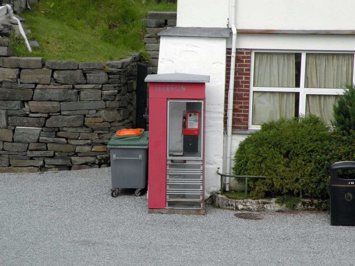 This is the story of how Norway’s most important conversation-space was designed by a young, freshly graduated man from Bergen.

“Norwegian architects are hereby invited…”
In the autumn of 1932, Oslo Telefonanlegginitiated an architectural competition. Finally, Oslo would get its own telephone booth. The city had had so called “talking-stations” from 1885, which in turn were overtaken by automatic telephones 
 only available at selected Narvesen kiosks. The state 
was of the opinion that now was the time to offer the public a better service; public telephone booths open 24/7, like the ones they already had in Sweden and England. But what would they look like, these new telephone booths? What considerations would it
 be necessary to take when designing it? The telegraph board developed a detailed list of demands and restraints: “The booth is intended to be placed outside on the streets and squares and need to be designed so that snow and ice does not hinder the opening and closing of the doors,” they wrote. “To prevent vandalism, theft, uncleanliness etc. inside the booth, it needs to be designed so that from all angles one may see what is going on in there.” Additionally, it would need to withstand storms and bad weather, and “preferably also being whipped by rain mixed with seawater” 

This was not all: The appearance would have to be «pleasing». The booth also needed to be movable, so that it could be taken in to be serviced at Telegrafverket’s main workshops. The reqired material was iron, and the surface was to be spray painted  preferably using car-body paint. There was a requirement for “a writing shelf, a pack shelf, and a suitable place for the telephone catalogue.” Also, there would need to be an illuminated TELEFON  sign, easily visible from all four angles. The total cost for each booth should not exceed 1000 kroner. The first prize for coming up with such a product was 800 kroner.

“Norwegianarchitects are hereby invited to partake in a competition for the design of a telephone booth…”  

The man with the solution
«At some point in 1932, Georg Fredrik sat at a party in Bergen. Maybe he felt a bit lost and forgotten as he often had throughout his life. He retreated to a quiet corner, took out a pencil and strted doodling on a matchbox.  According to my mother, this was how the telephone booth came into being.” In the book “Norges lille røde  historien om telefonkiosken,” Lars Fasting describes his father, the man who is far less known than the iconic architctural structure he left behind. Georg Fredrik Fasting was from Bergen, born into a family of working people and smallholders. One unusual facet of Georg Fredrik was that he was born without ears. His mother made sure he learnt to speak, read and write, 
ut Lars Fasting indicates that his father would seek refuge in drawing when the social challenges became too much to bear. And in the end drawing became his profession. In 1924 he secured a guarantor for a student loan, and started studying to become an a
rchitect at the NTH. Throughout the 1930s he entered several architectural competitions, with drafts produced, according to his son, “after work and in the late hours of the night.”

His efforts were not wasted. Out of 93 entries, with names such as “Flirt”, “Brrr”, “Ring” and “Amor”, the jury selected Fasting’s submission, “RIKS” as the new telephone booth: “The draft shows a strikingly simple solution to the task, technically as well as aesthetically well worked out.”

Taut and provident
Simple and aesthetc are the keywords here. Fasting had designed a booth pointing towards the future, and to modernism. Just how modern it was can be seen by comparing RIKS to the British telephone booth, also designed in the interwar-era. While the British version with it classicistic style is looking back to the heyday of the empire, Fasting’s booth is progressive and functionalistic. Like most Norwegian architects, Fasting broke with the classicistic style of architecture after the Stockholm-exhibition in 1930. “After it, almost all buildings erected in Norway until the German invasion in 1940, were in the functionalistic architectural style,” writes senior curator of architecture at the Norwegian National Museum, Ulf Grønvold, in the book, “Den lille røde”.“TheNorwegian booth is a piece of functionalistic architecture, an asymmetric composition with its roof slab overhanging the word TELEFON, in bold sans seraph lettering,”concludes Ulf Grønvold.

Fashionably red
And it was red. Fasting chose a colour which was part of the modern palette. “A bright red colour, but not as shiny as a signal red, the character of the colour places it among the fashionable colours within functionalism,” states paintings conservator and researcher in NIKU (Norwegian Institute for Cultural Heitage Research), Jon Brænne. In his opinion, Fasting went for visibility without making the booth stand out too much from its surroundings. The original colour was in use up to around 1950, when it changed to signal red. Towards the end of the 1970s the clour was again adjusted towards today’s orangey red.

The design, however, has not changed. RIKS is eighty years and still looks remarkably good. That’s what makes Fasting’s telephone booth a classic  even before it was added to DOCOMOMO’s list over moden icons of design. For Telenor, the telephone booth has served as a pathway into the hearts of the public. For many, Telenor (Televerket) was synonymous with exactly this telephone booth, because this was where one would go to place a call. Having a home
phone was not common until the 1980s. As such the red box became part of the Norwegian everyday and consciousness. The symbol- and publicity value of this is hard to evaluate, but in 2007 it was time to give honour where honour was due, Telenor, in consul
tation with the Directorate for Cultural Heritage, decided to preserve 100 telephone booths for all eternity.

And what about Georg Fredrik Fasting? What happened to him? At the age of 56 an entry in his diary states: «I CAN HEAR». As the first person in th world he had undergone an operation where he had ear canals constructed and eardrums fitted. For the rest of his life, the man behind Norway’s own telephone booth could answer the telephone himself.

Source: Norges lille røde historien om telefonkiosken (2007), issued by The Norwegian Telecom Museum and Telenor Cultural Heritage.