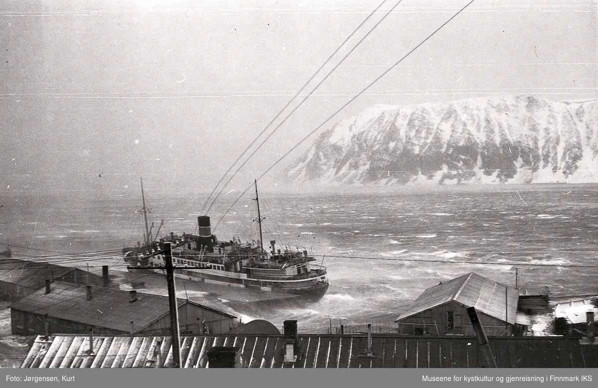 Gjenreisning. Storm i Honningsvåg. Hurtigruta legger til kai. Brakkebebyggelse i havneområde. 1946/47.