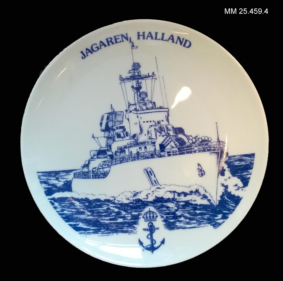 Tallrik i vitt porslin. På framsidan en avbildning av jagaren Småland till sjöss med texten "Jagaren Halland" över motivet. På baksidan text som förklarar att tallriken ingår i en serie av tallrikar med motiv av svenska örlogsfartyg.