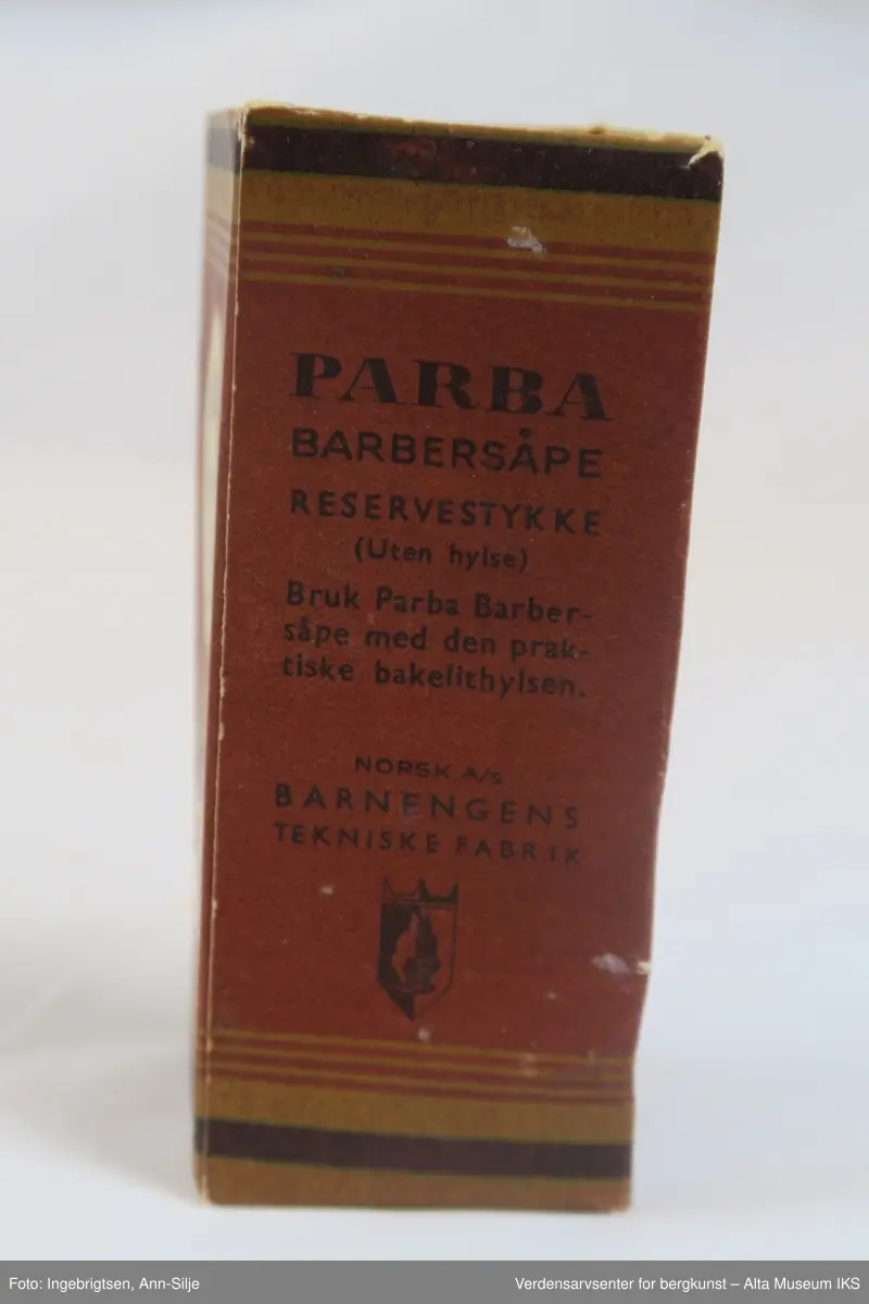 Rektangulær eske med en sylinderformet såpe på innsiden.