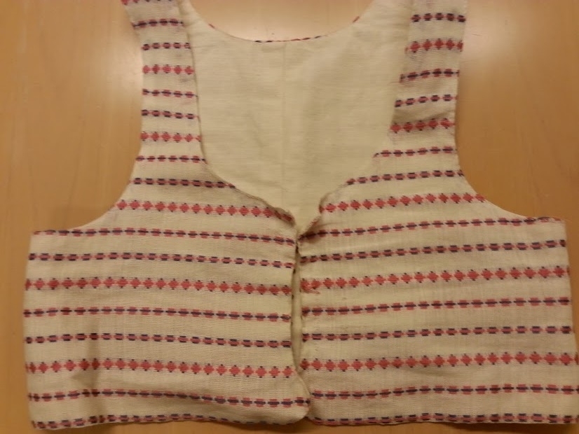 Hembygdsdräkt från Breared,Halland.
SKJORTA i Linneväv Handsydd med lingarn och med broderad smock på handled och överarm med röd och vit bomullsgarn. broderi på krage och knäppslå.
LIVSTYCKE: Handsytt Yttertyg Handvävt i rosa och blå opphämtaränder på blekt tuskaftsbotten. Blekt linnefoder.
KJOL: Handsytt i blå tuskaftsylle, 3 meter i omkrets med smockveck i midjan från - höftkam - bak - höftkam.
Linning knäppe fram.
FÖRKLÄDE: Handsytt av Handnävt i rosengång med rosa, blått och vitt bomullsgarn.
SJAL: 1/2 Fyrkant delad på tvären.Handvävd i tuskaft med blått Bomullsgarn .
Broderad mit bak med silketråd i rosa,grön mm.
HÄTTA: broderad med silkegarn på blått sidentyg och monterad på mjuk stomme.
KJOLVÄSKA: Handsydd av röd ylleväv,fodrad med oblekt linneväv, blå -grönt band runt ytterkant och monterad med silverbygel, broderad med blå,gul,vit ullgarn,