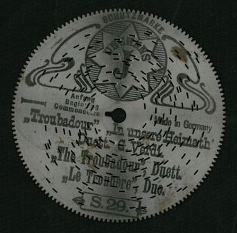 Perforterte metalplater med pigger på undersiden. Programmert musikk for platespilledåse.
30-spor, Ø 11.5 cm (4 1/2').
Drivsystem: Sentrumshull med tunge (4mm lang) samt tagger (2 mm lange) perifert langs kant, som et tannhjul. 
U-formet pigger på undersiden av platene.

Sentrumhull, diameter: 7,8 mm
Avstand mellom 10 spor: 13 (mm, ca)
Avstand sentrumsaksling – første spor:  14,5 mm
Total bredde spor:  37,3 mm

Platene er for øvrig kompatibel med Symphonion Simplex (30-spor, Ø 11.5 cm)