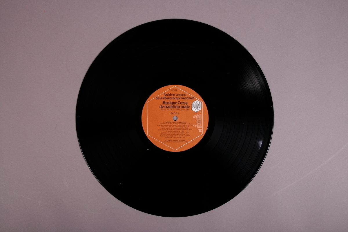 Plateomslag i form av en eske i oransje stoff, tre grammofonplater i svart vinyl som ligger i papirlommer, samt et hefte. I tillegg et klistremerke inne i  esken.