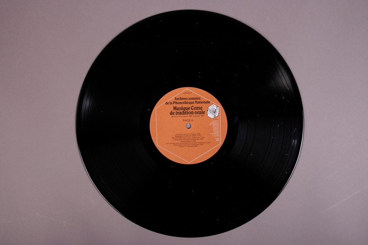 Plateomslag i form av en eske i oransje stoff, tre grammofonplater i svart vinyl som ligger i papirlommer, samt et hefte. I tillegg et klistremerke inne i  esken.