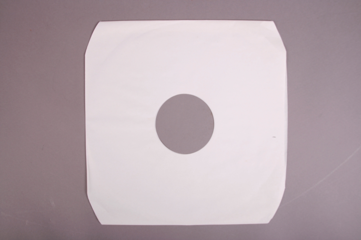 Plateomslag i form av en eske i oransje stoff, tre grammofonplater i svart vinyl som ligger i papirlommer, samt et hefte. I tillegg et klistremerke inne i  esken.